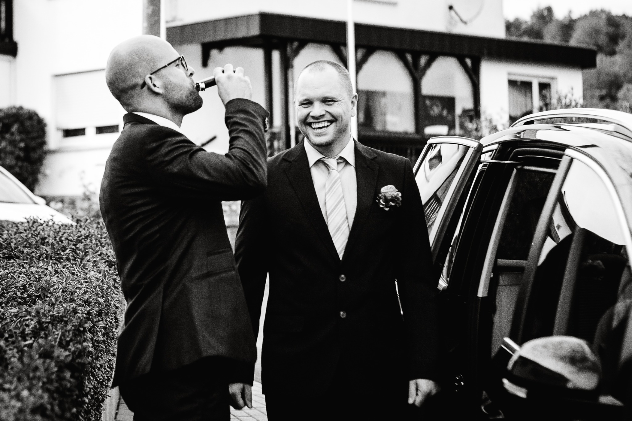 Two men laughing at a wedding